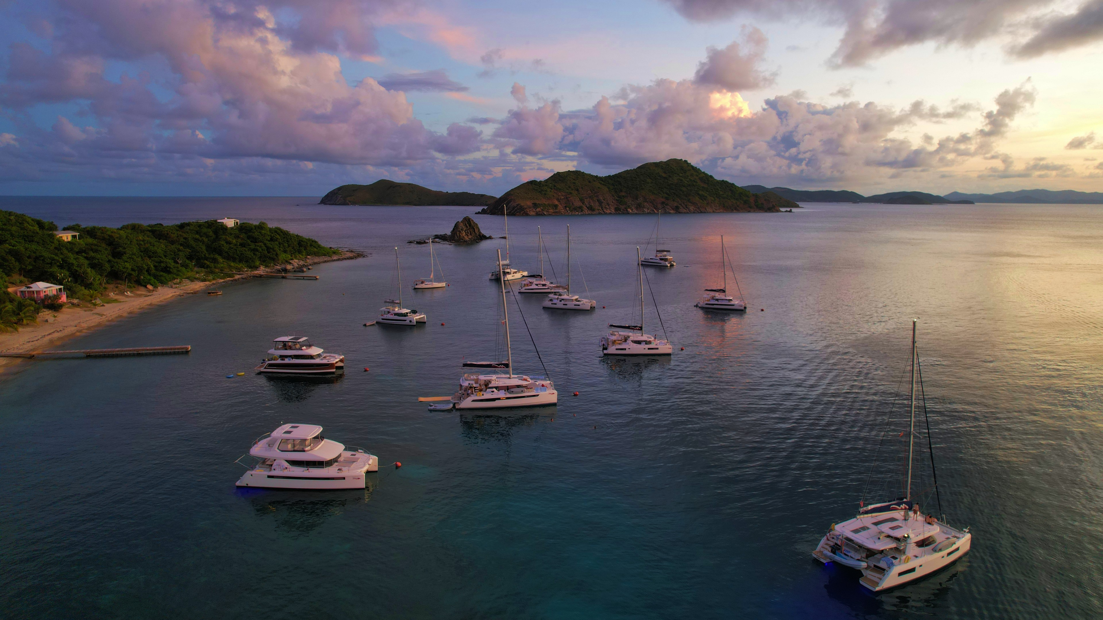 Fleet of charter yachts anchored at Cooper Island in the BVI at sunset