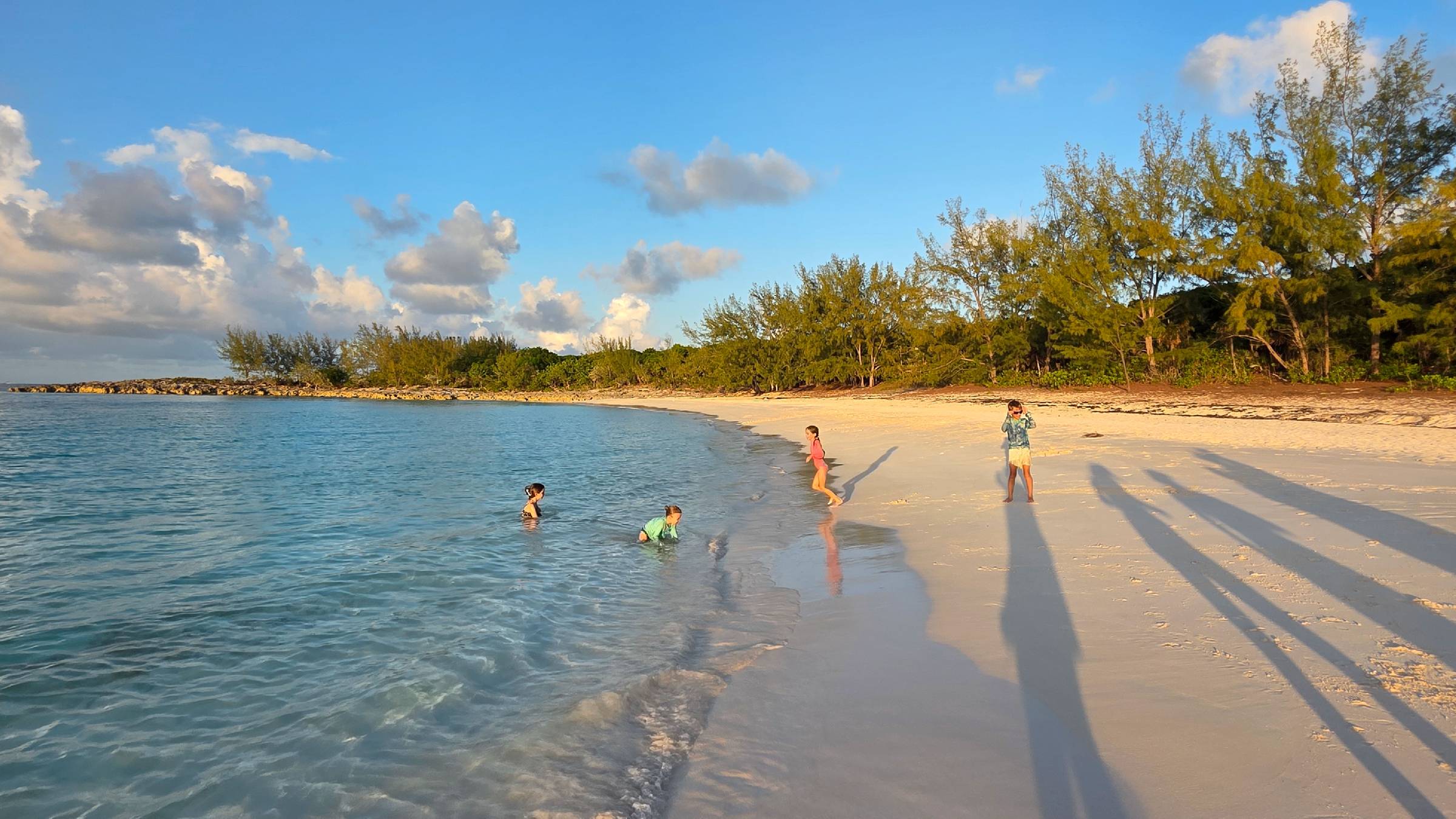 Family enjoying a beach at sunset during a charter vacation